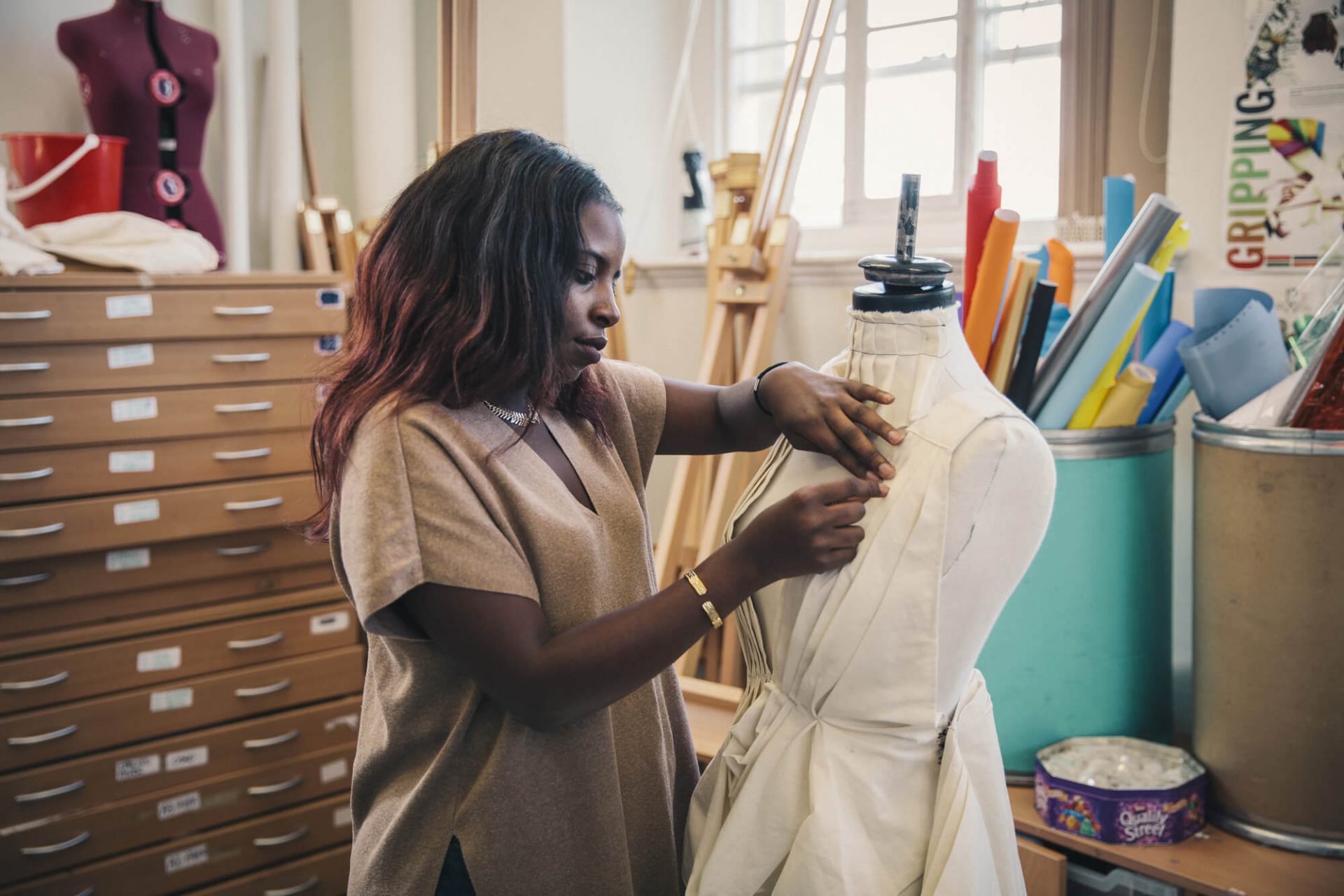 Fashion student works on a dress in an art-room in evening, part-time class